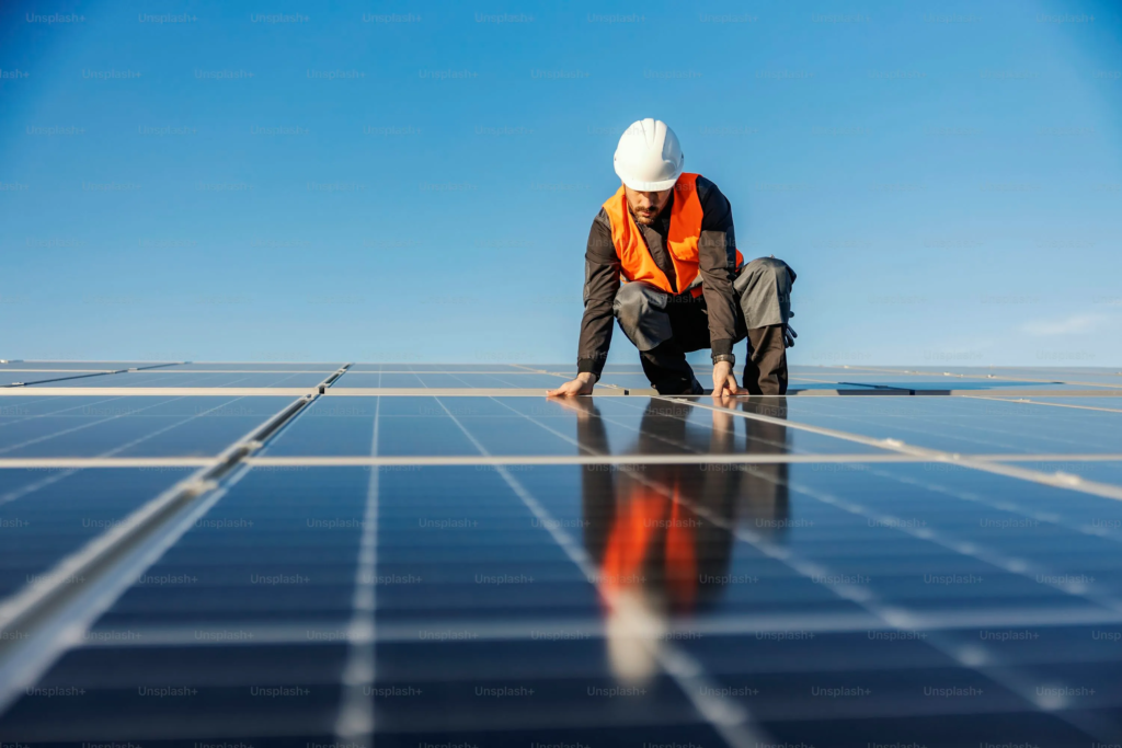 An expert man installing solar panels on the roof.